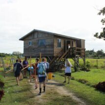 A mission group arriving at an unpainted house preparing to paint